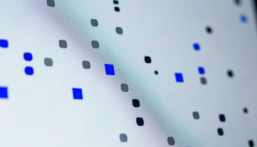 An abstract close-up of a digital screen showing distinct dead pixels scattered across the surface, creating a visually striking pattern. The foreground highlights the dead pixels in vibrant colors like deep blue and dull gray, contrasting against a bright and luminescent background that mimics a powered-up electronic device. Soft, diffused lighting enhances the texture and details of the screen, casting gentle reflections that create a slight glow around the dead pixels. The composition is shot from a slightly tilted angle, emphasizing the irregularity and randomness of the pixel malfunction. The overall mood conveys a sense of technical intrigue, inviting viewers to ponder the nature of technology and its imperfections.